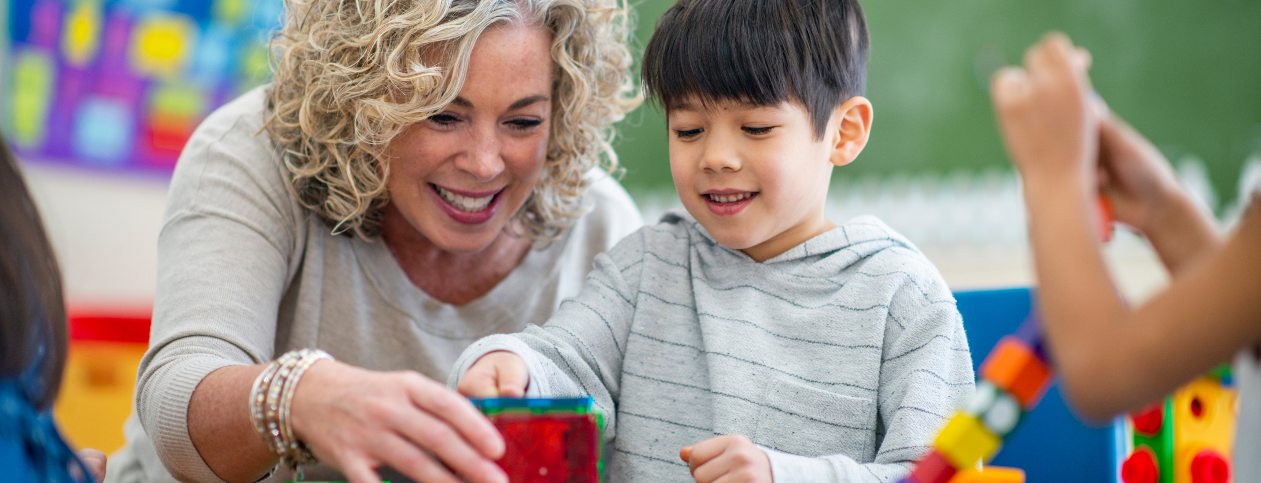 Teacher helping young student in class.